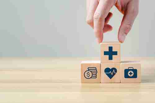 Hand legt einen Holzblock auf andere Blöcke